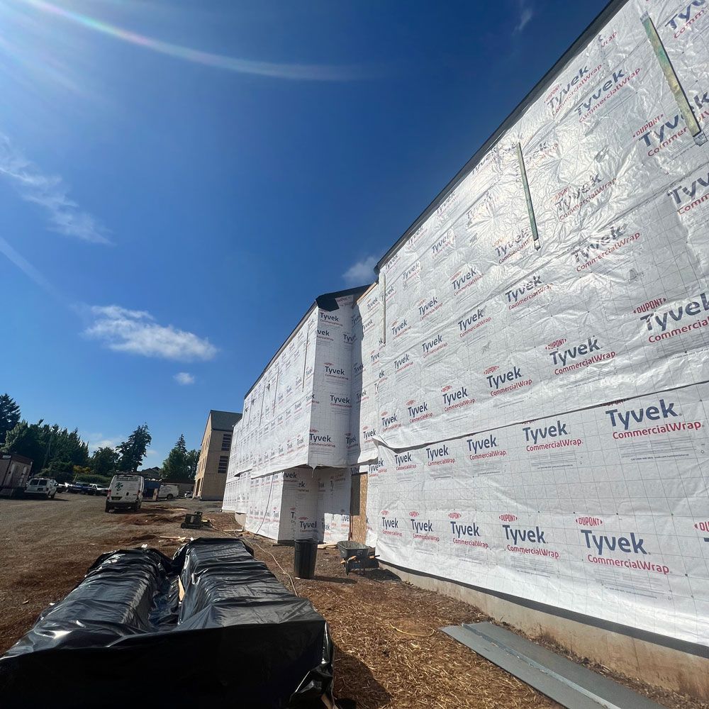 A building is being built with tyvek insulation on the side of it.