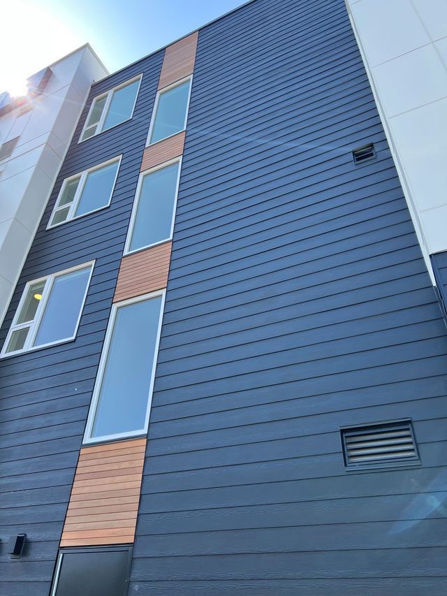 A tall building with a lot of windows and a blue sky in the background.