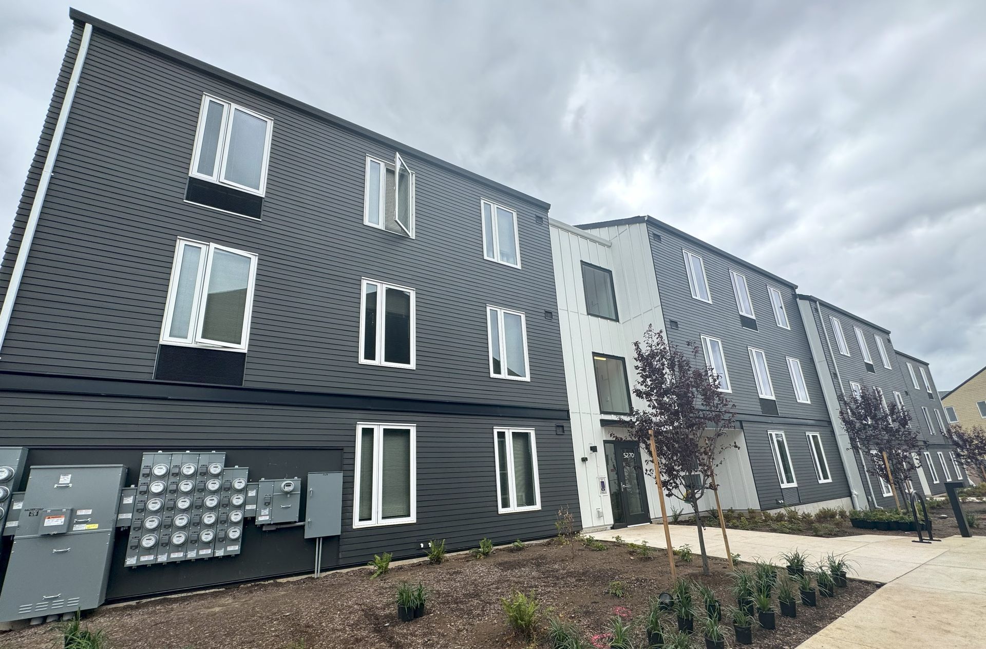 A large apartment building with a lot of windows on a cloudy day.
