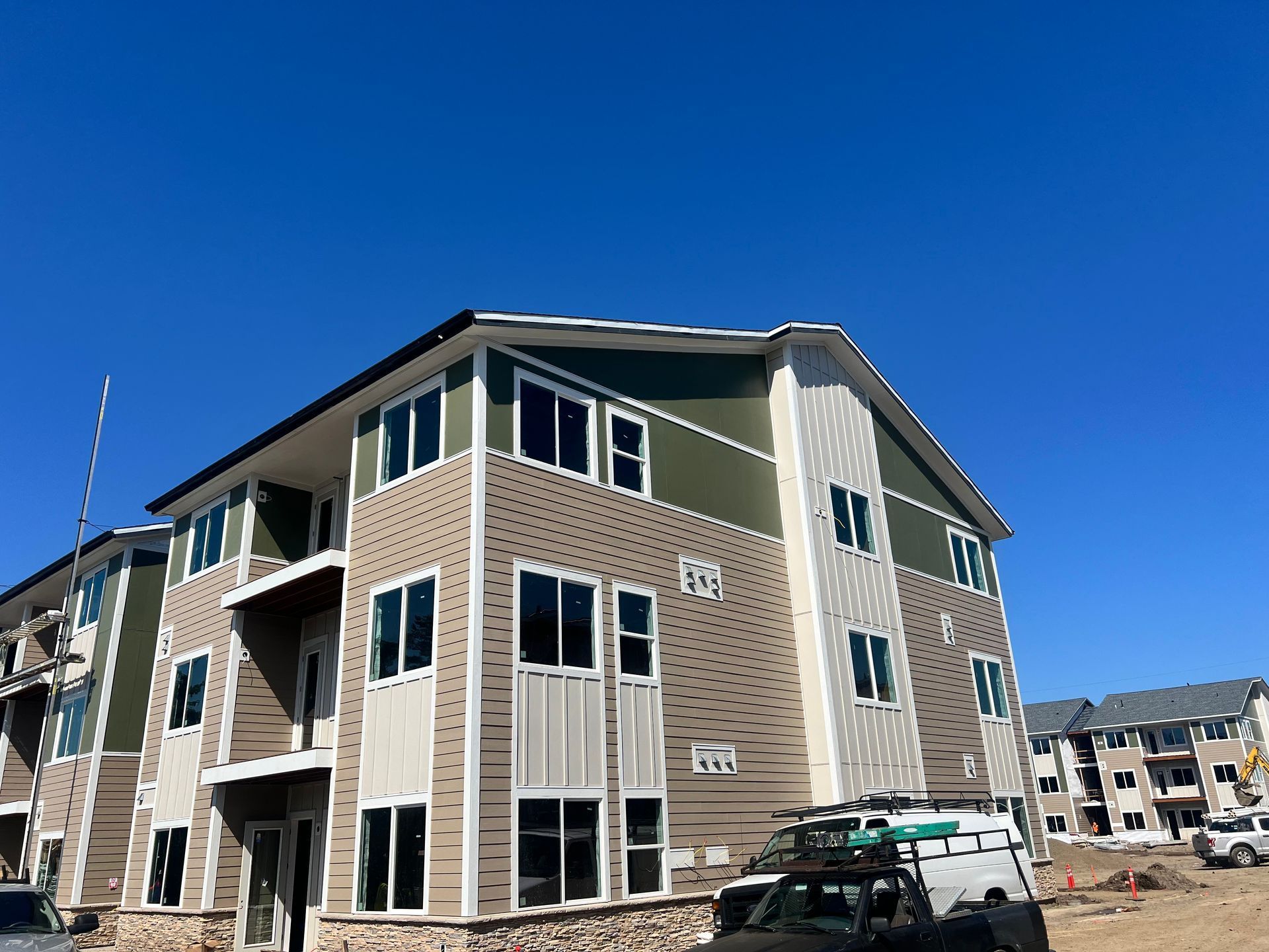 A large apartment building under construction with a truck parked in front of it.