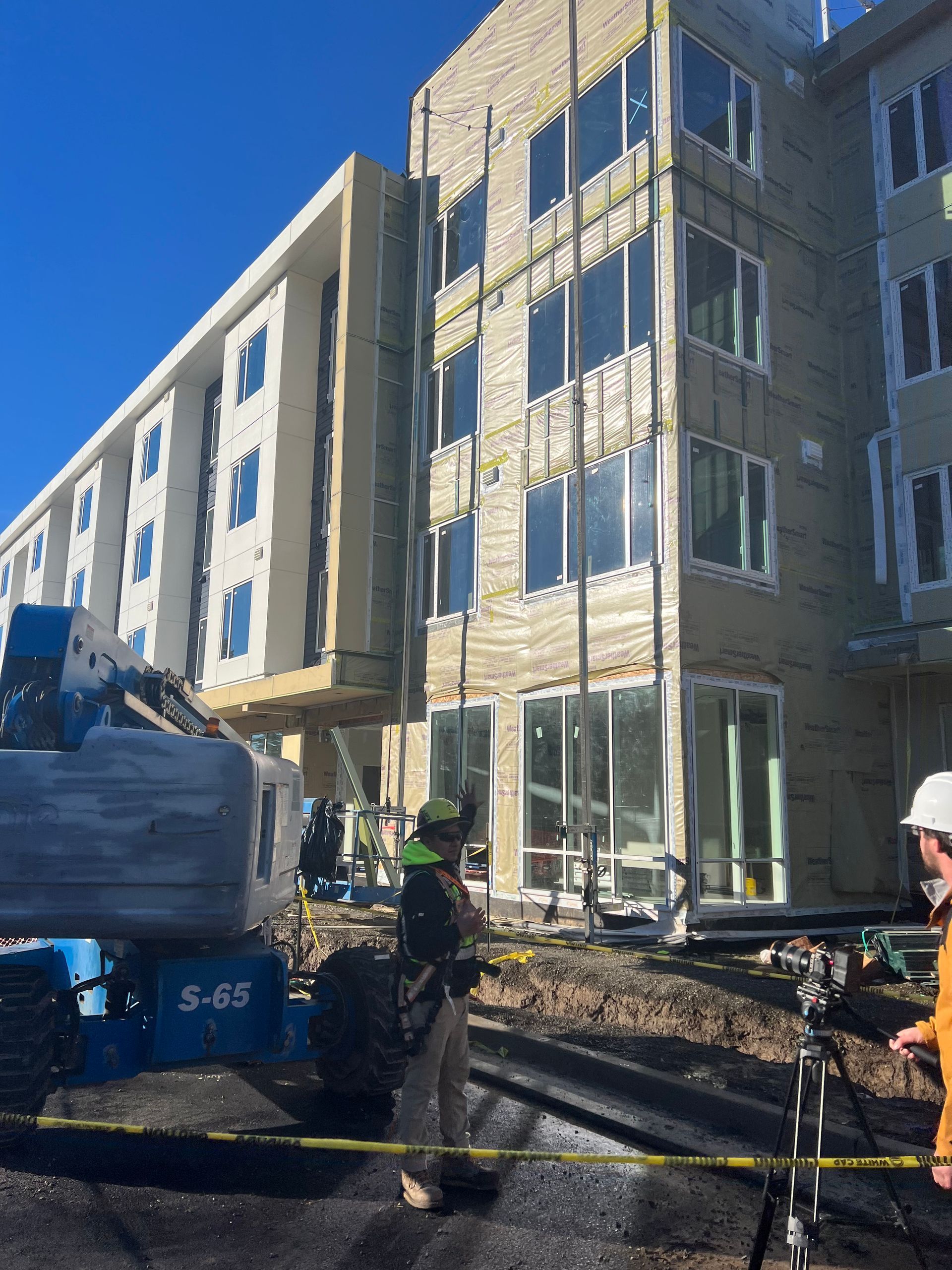 A man standing in front of a building that says s-65 on it
