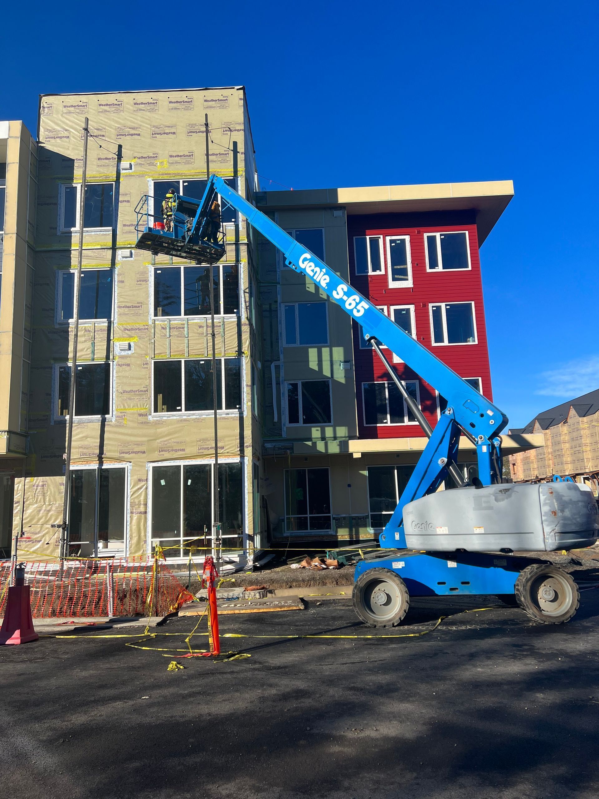 A blue genie lift is being used to work on a building