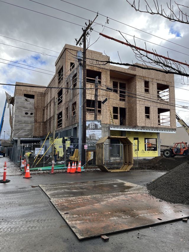 A large building is being built on the side of the road.