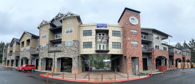 A large apartment building with a red truck parked in front of it.