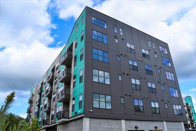 A large apartment building with a lot of windows on a cloudy day.