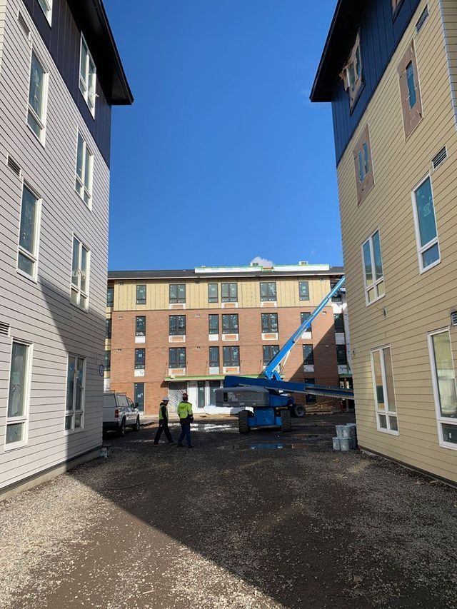 A group of people are standing in a courtyard between two buildings.