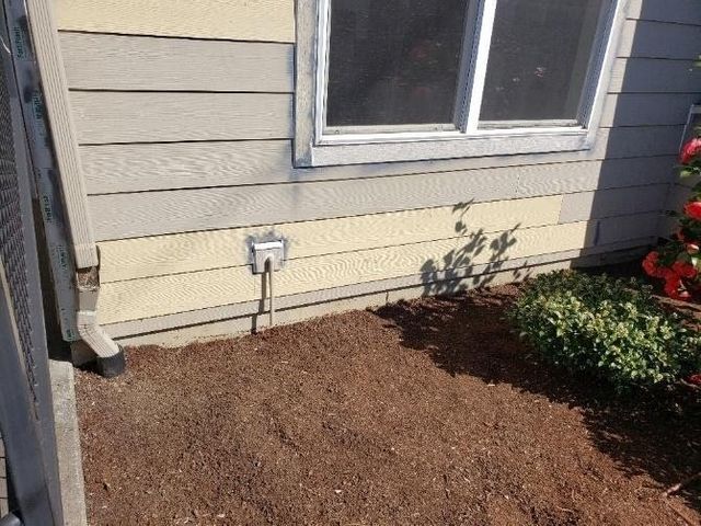 A house with a window and a drain on the side of it