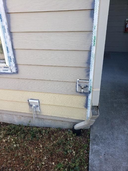 A close up of a house with a drain on the side of it.