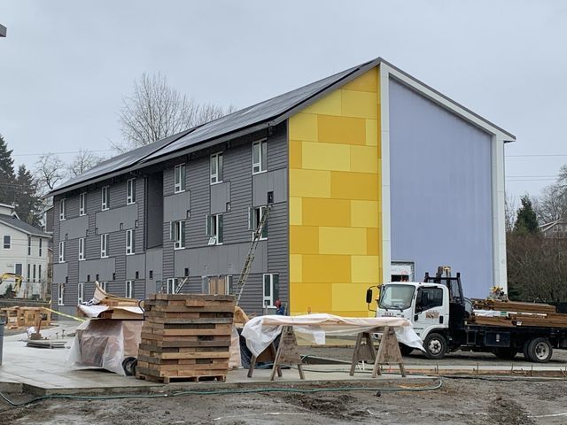 A white truck is parked in front of a building under construction