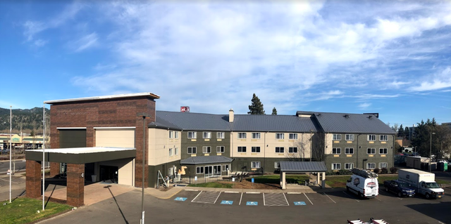 A large building with a parking lot in front of it.