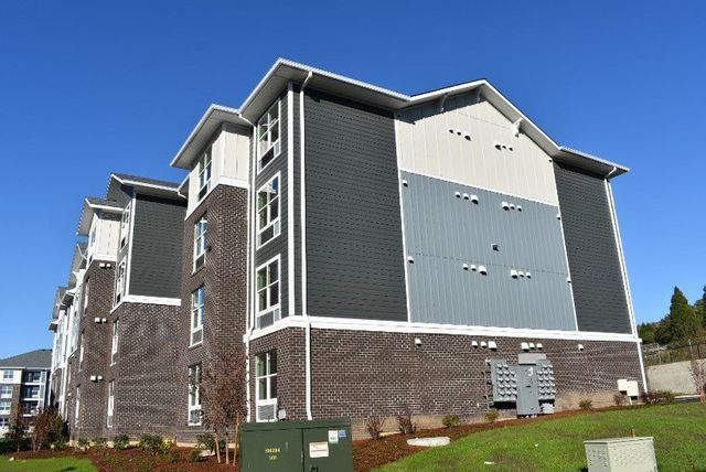 A large apartment building with a blue sky in the background