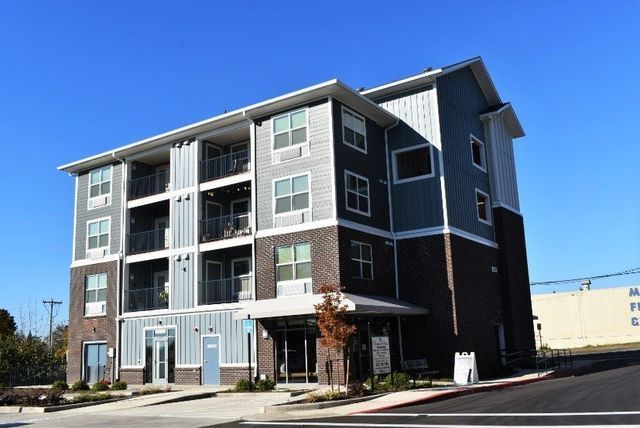 A large apartment building with a lot of windows on a sunny day.
