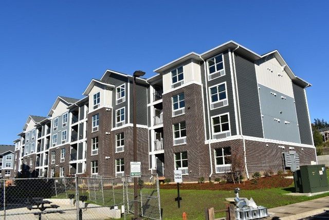 A large apartment building with a blue sky in the background