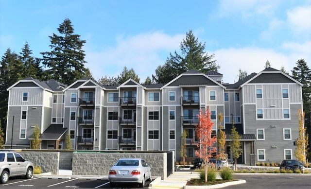 A large apartment building with cars parked in front of it