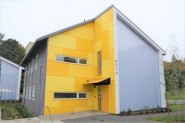 A yellow and blue house with a gray roof