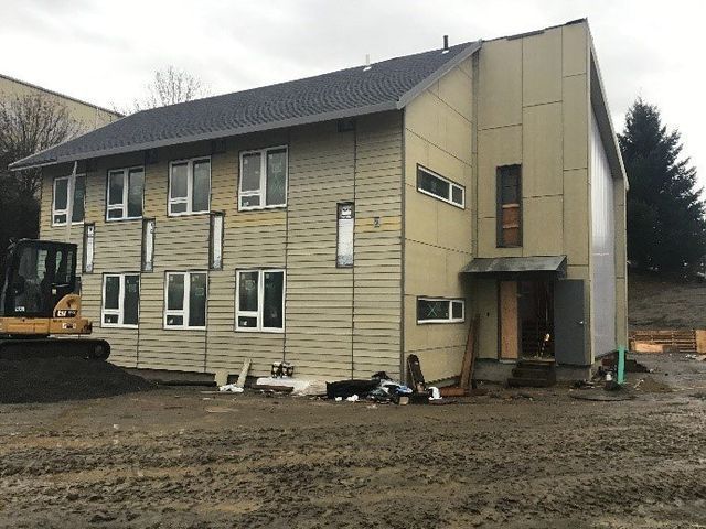 A large building with a bulldozer parked in front of it.