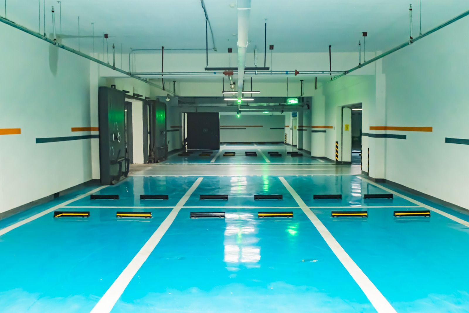 An empty parking garage with blue and white lines on the floor.
