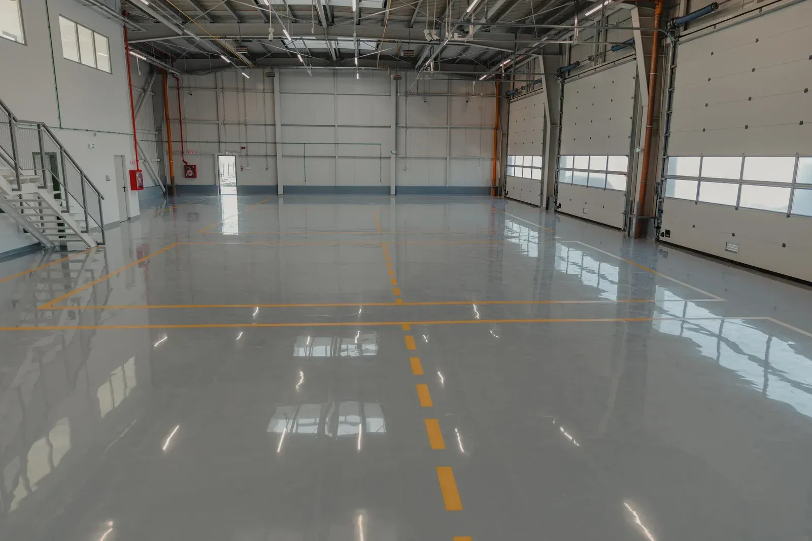 A large empty warehouse with a shiny concrete floor.