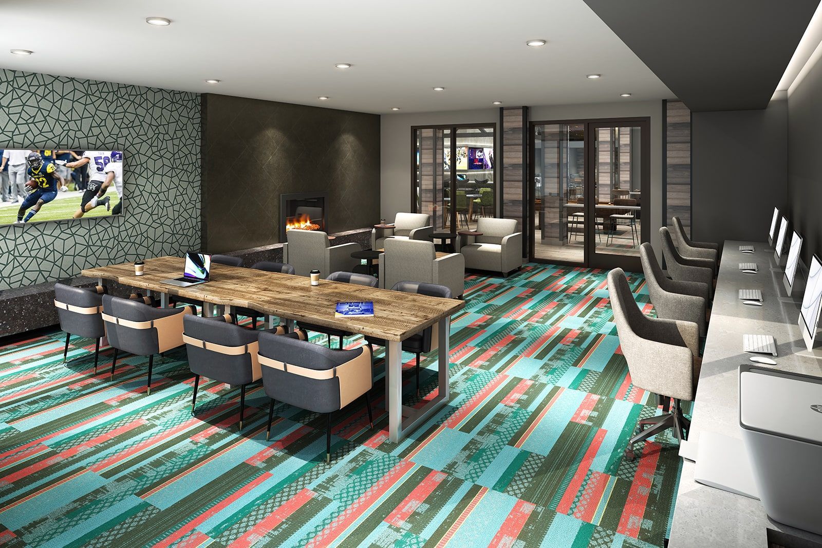 Modern resident lounge with fireplace, long wooden table, couches, and computer stations.