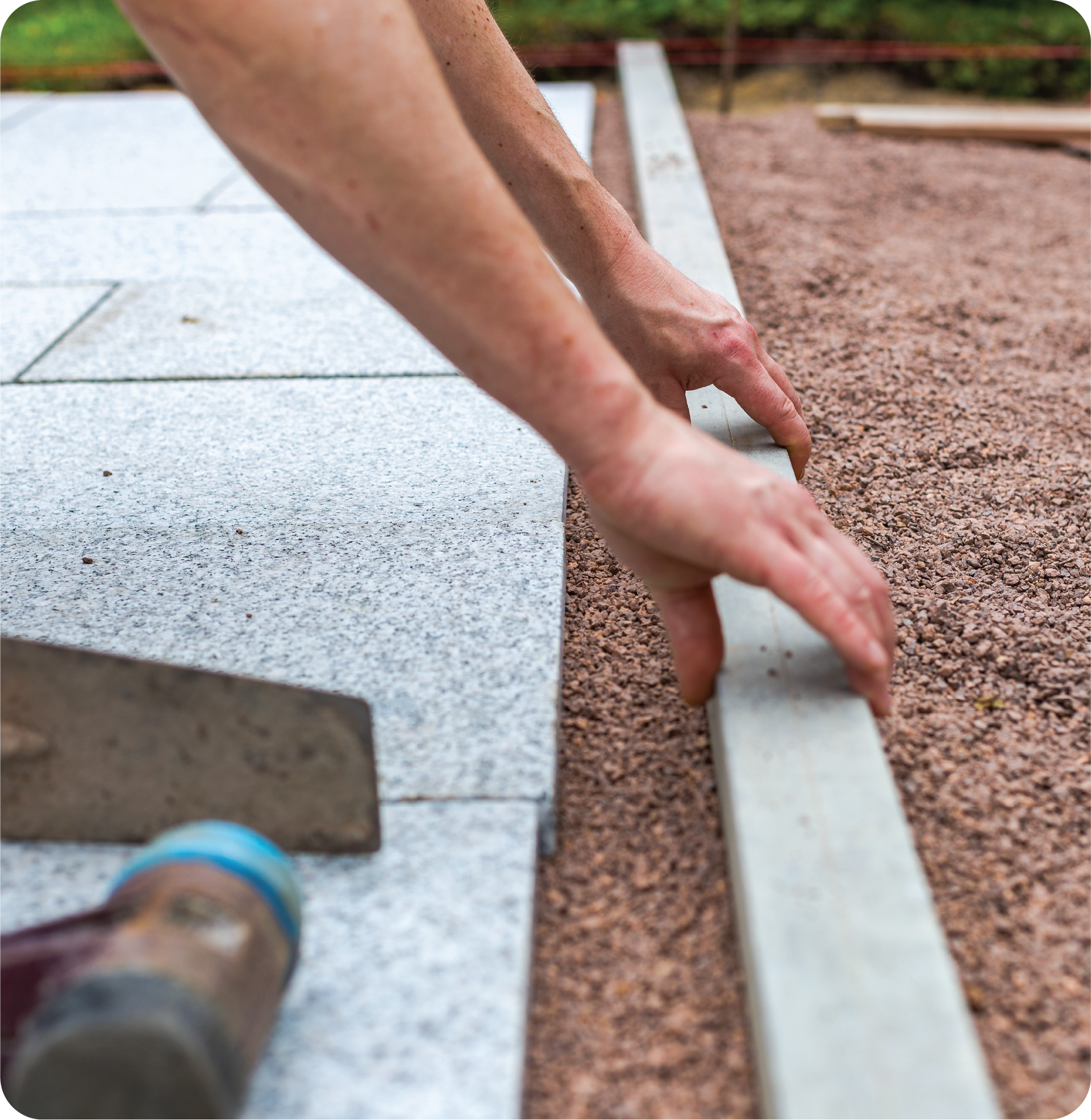 A person is laying a concrete border on a patio