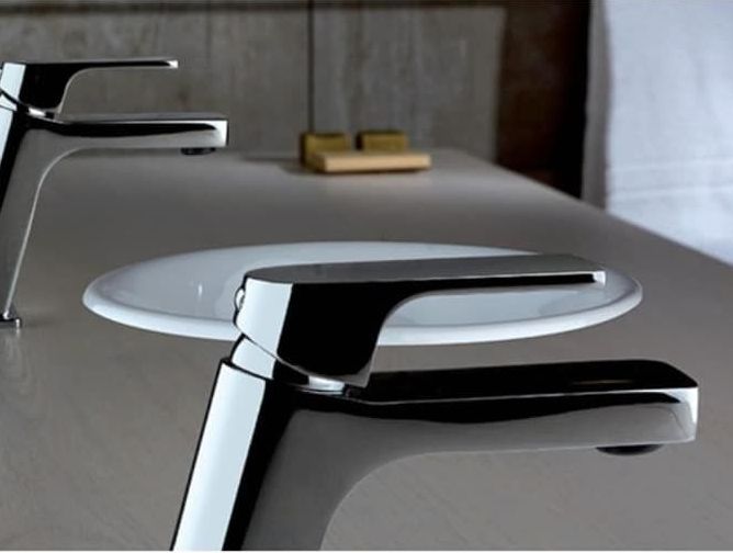 Due rubinetti e un lavandino su un bancone in un bagno