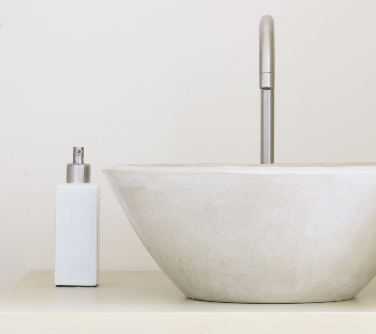 Un lavandino del bagno con accanto un dispenser per il sapone