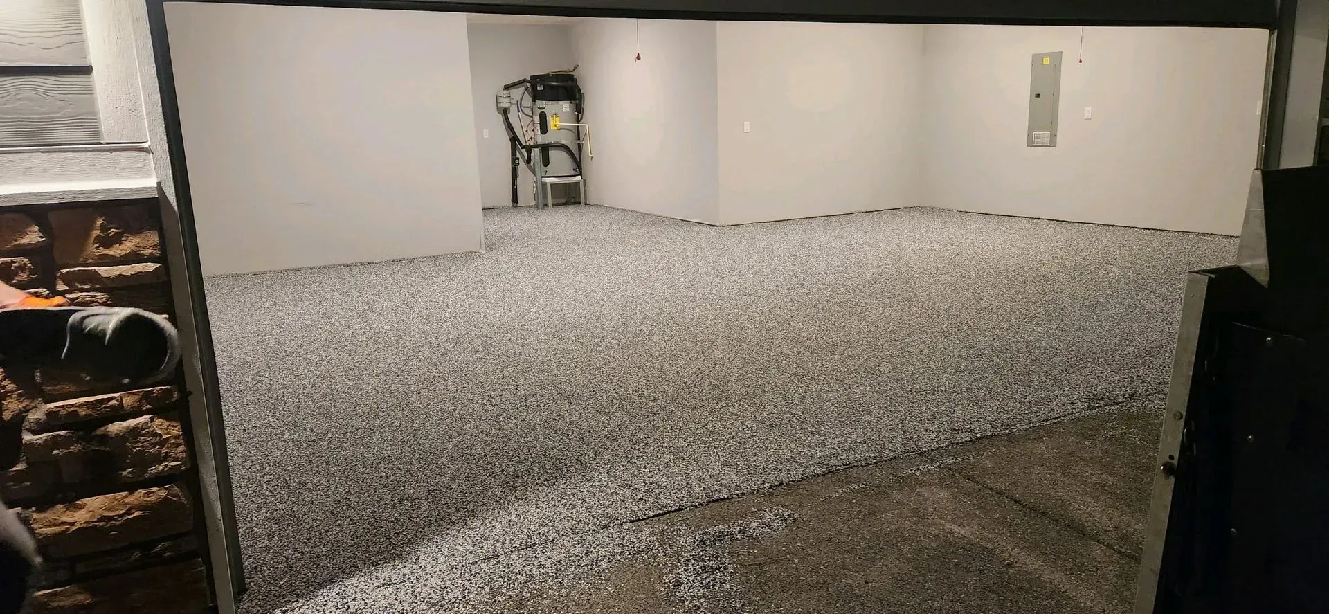 Basement with gravel floor, white walls, and a utility cart.
