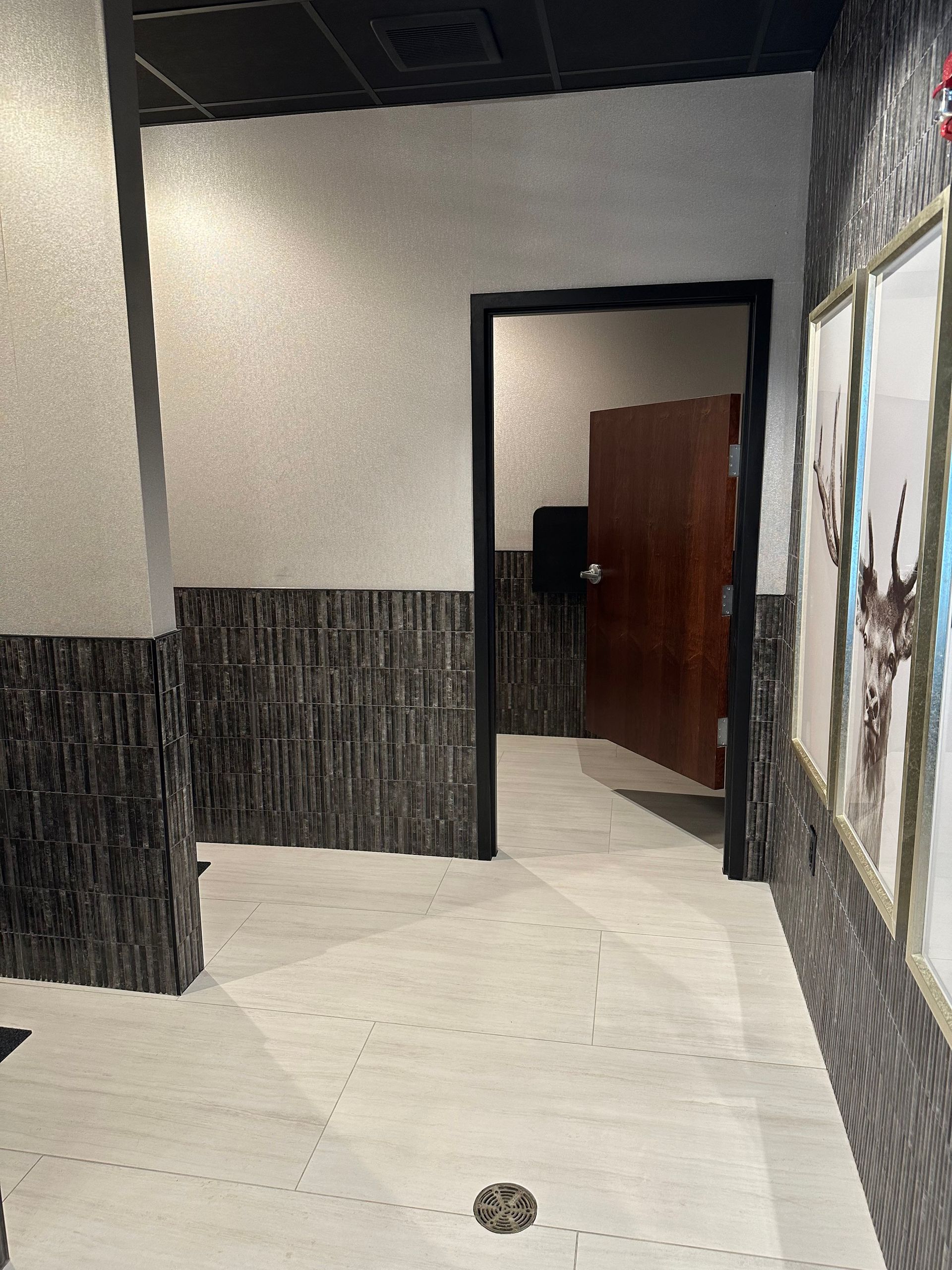 Hallway with textured walls, tile floor, and a doorway leading to a room with a closed brown door.