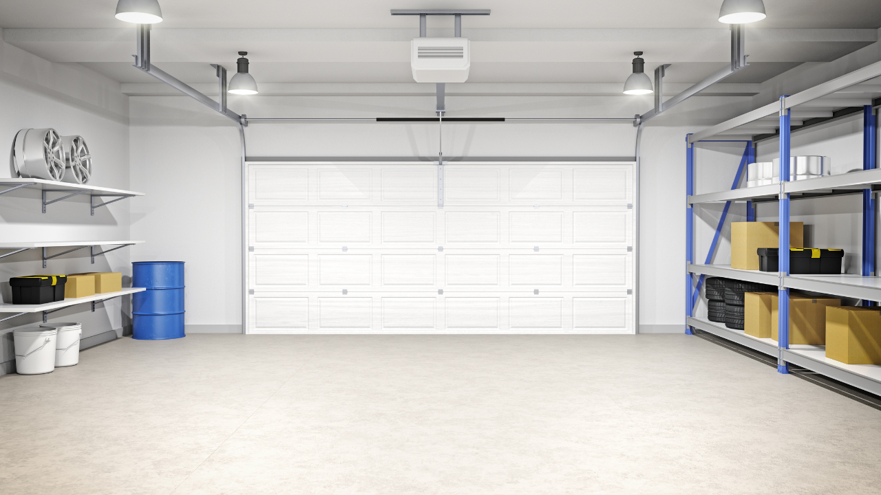Clean, white garage interior with closed garage door, storage shelves, and overhead lighting.