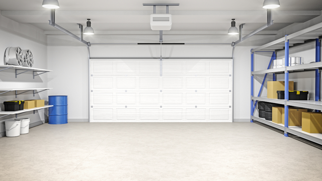 Clean, white garage interior with closed garage door, storage shelves, and overhead lighting.