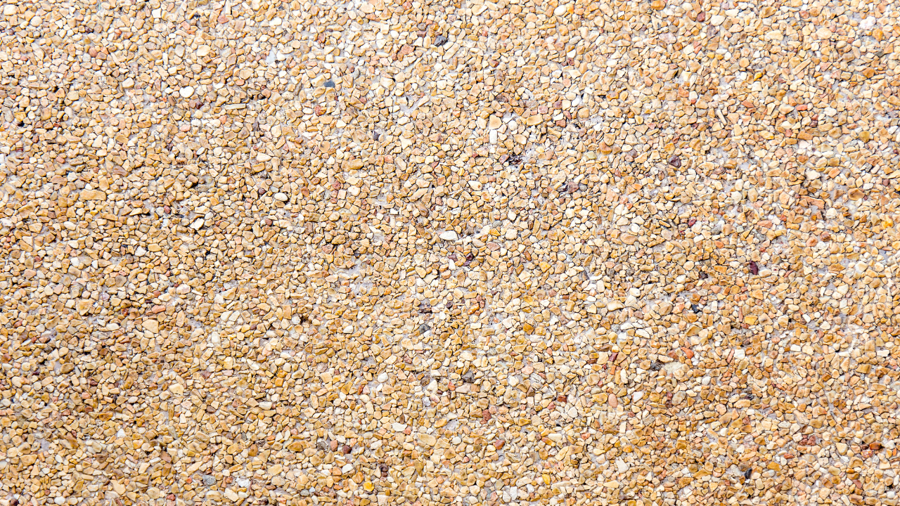 Close-up view of light-colored sand grains with variations in texture and shade.
