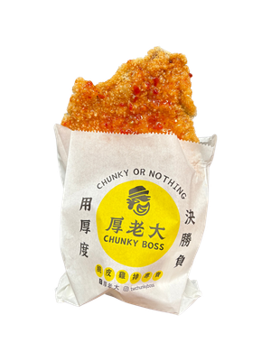 A large, crispy, fried chicken cutlet in a white paper bag with the words 