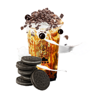 Tiger Sugar drink with Oreo cookies and toppings. Brown sugar layers, whipped cream, and dark chocolate crumble are visible.