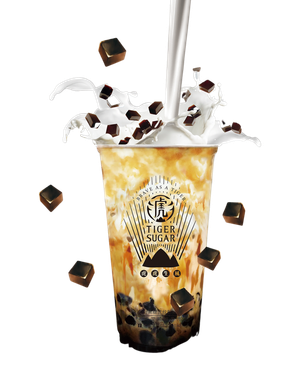 Tiger Sugar bubble tea with milk pouring in, brown sugar pearls, and floating brown sugar cubes.