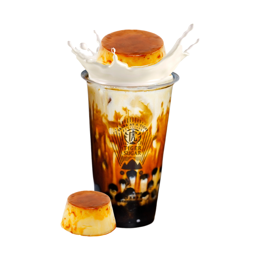 Tiger Sugar bubble tea with a flan on top and one to the side, brown and tan with a milk splash.