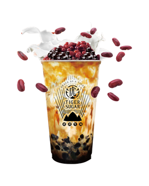 Tiger Sugar drink: layered brown sugar milk tea with tapioca pearls, topped with red beans and whipped cream, scattered with beans.