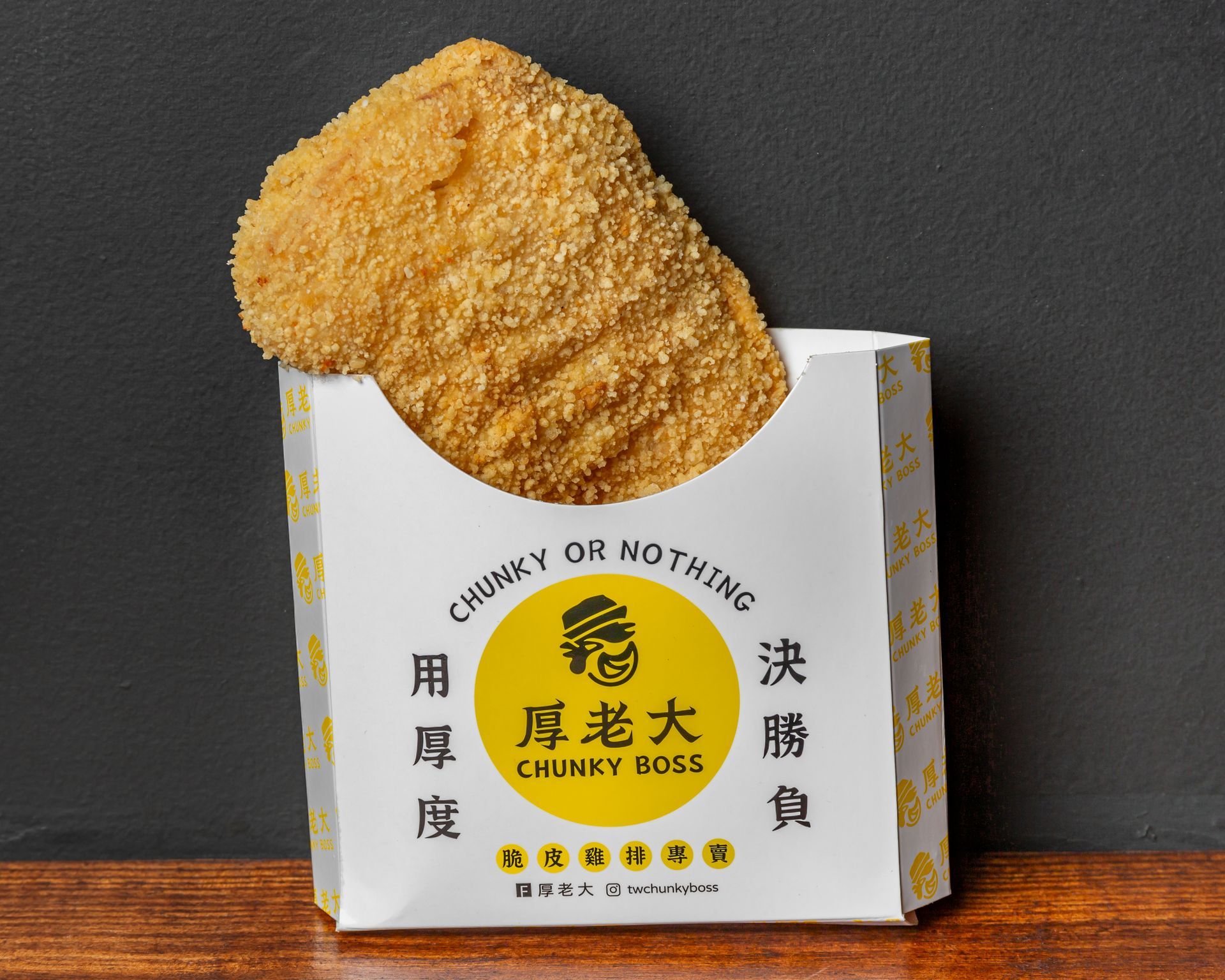 A large, breaded chicken cutlet in a white and yellow 