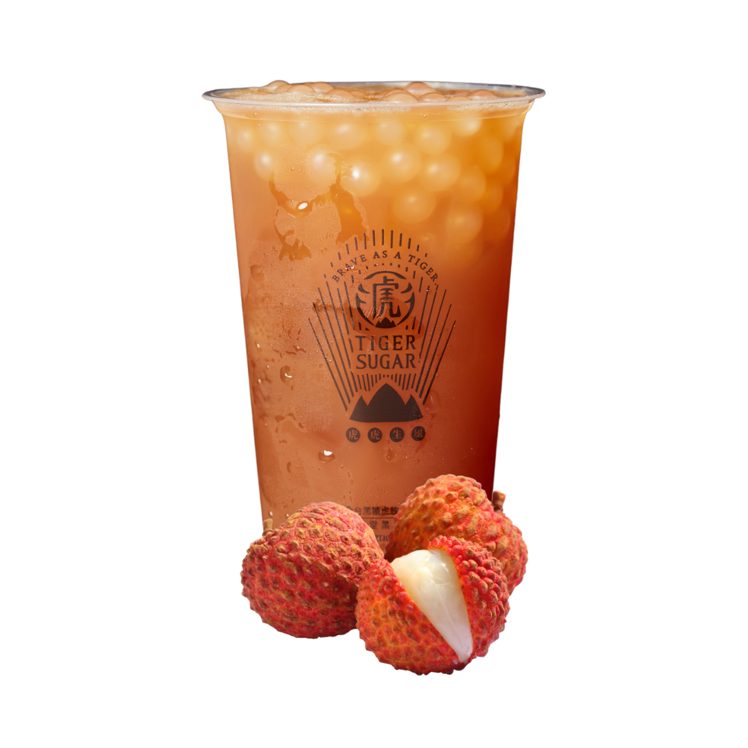 A tall plastic cup of lychee-flavored bubble tea with lychees in front, branded with 