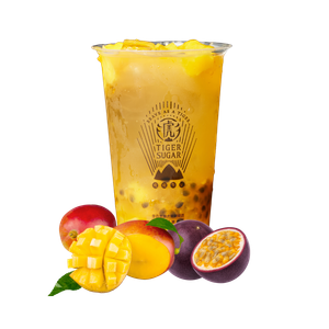 A tall glass of Tiger Sugar mango and passion fruit drink, garnished with mango chunks and surrounded by fresh fruit.