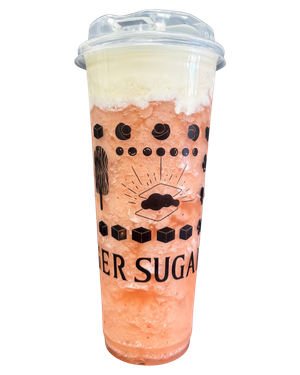 Tall plastic cup with a pink, slushy drink topped with white foam. The cup has black designs and 