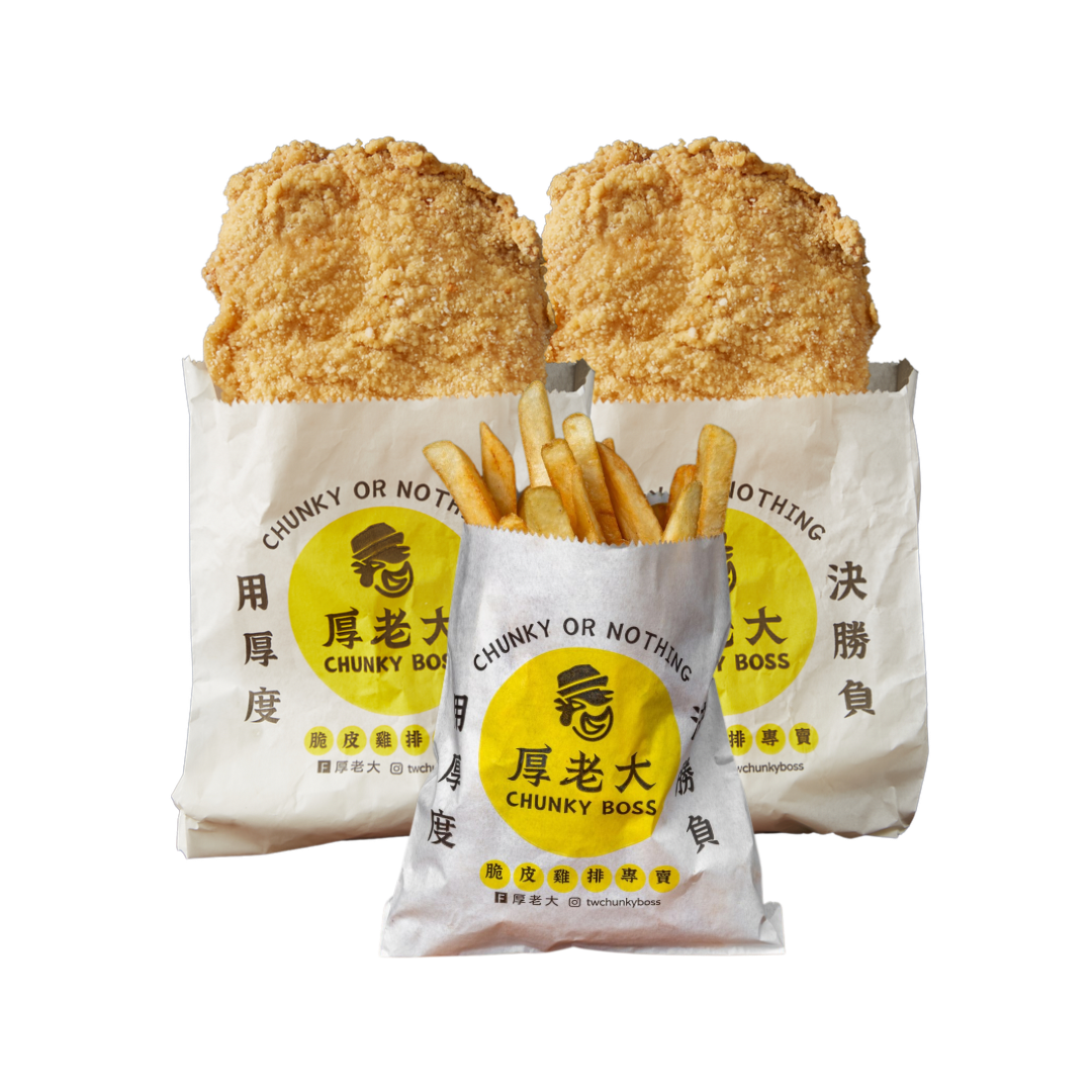 Two large fried chicken cutlets and a side of french fries in white paper bags, with the 