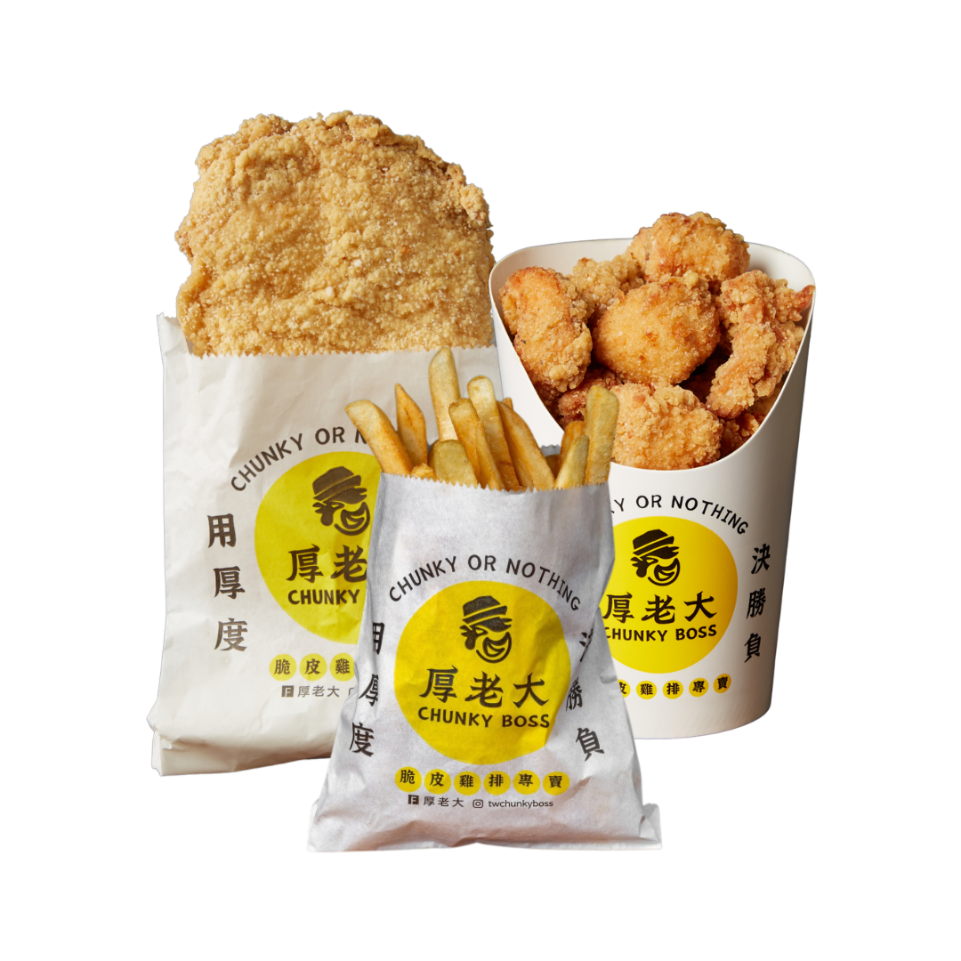 Fried chicken meal: large, crispy chicken breast, popcorn chicken, fries, in paper bags with yellow logo.