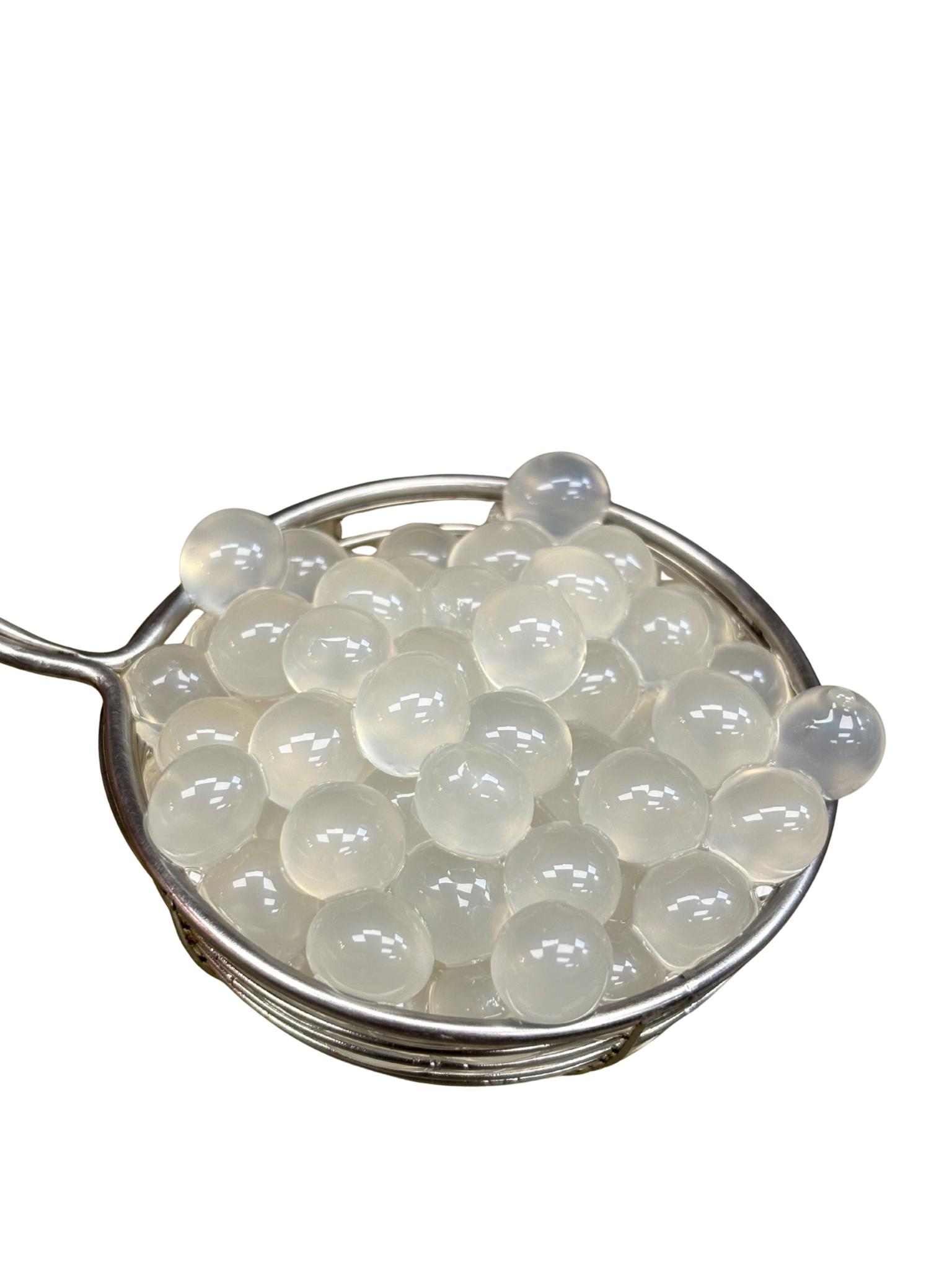 Clear, translucent boba pearls in a silver mesh strainer.