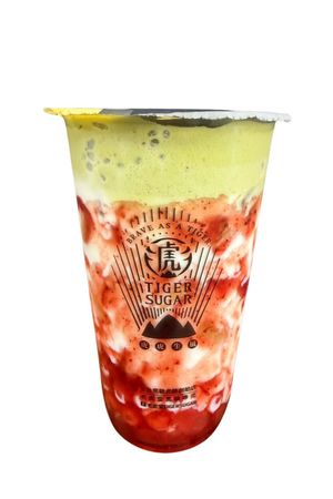 Tiger standing next to a bubble tea drink, with brown coffee beans in front.