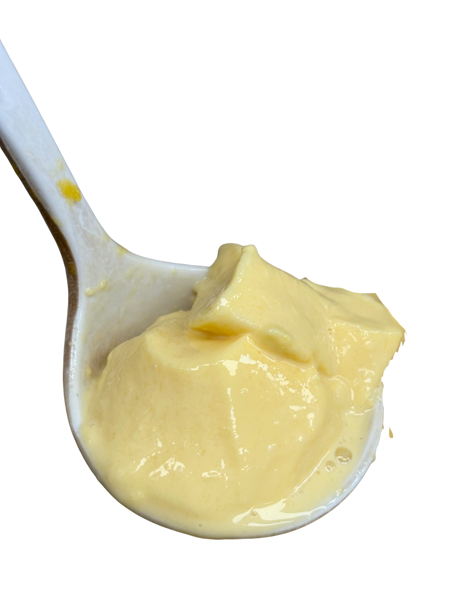 Close-up of a white spoon holding a portion of yellow pudding.
