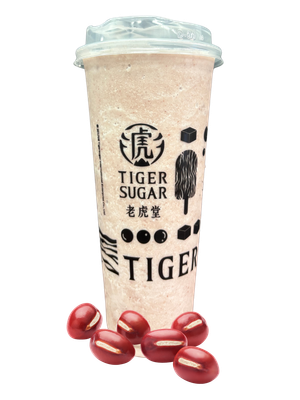 A Tiger Sugar beverage, a tall cup with a clear lid, red beverage. Red beans are scattered around it.