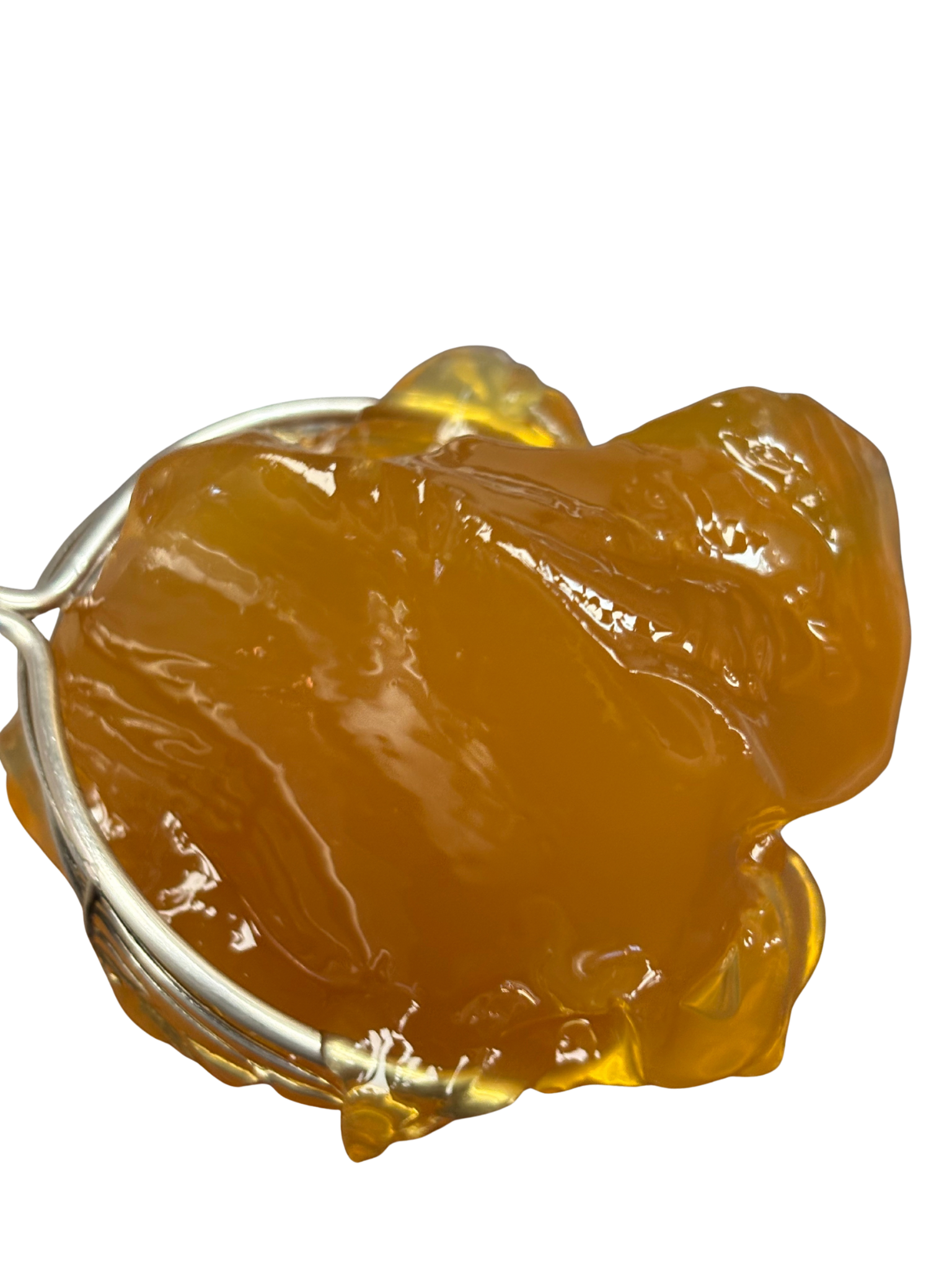 Yellowish-brown, sticky substance held by a metal tool.