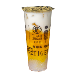 Tiger Sugar Mango Boba drink in a clear plastic cup, layered with mango, white cream, and boba. The cup has the Tiger Sugar logo.