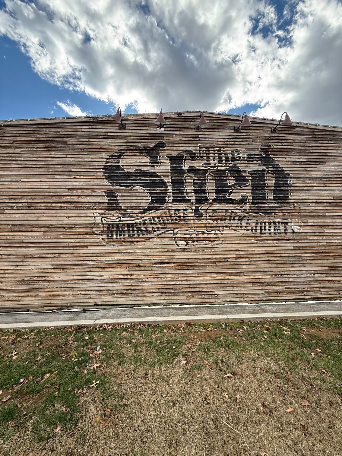 A large wooden wall with the word shed painted on it