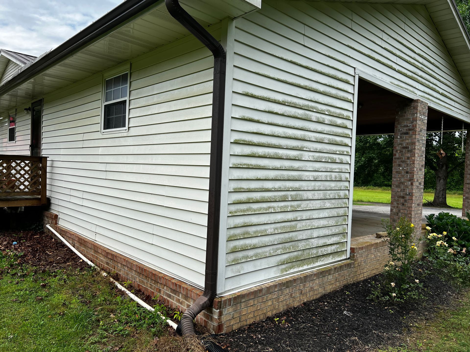 A white house with a gutter on the side of it